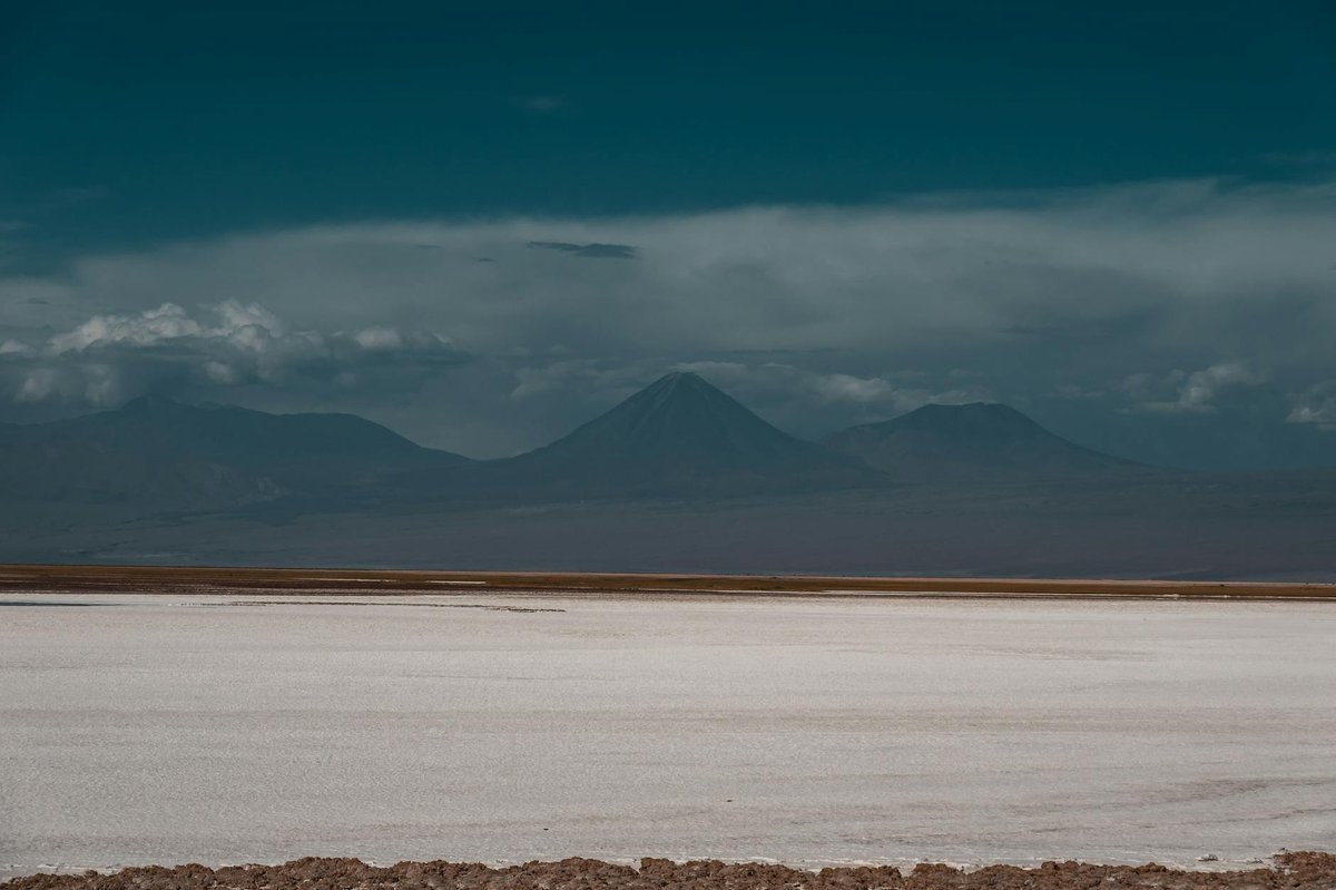 Vast Atacama Desert landscape with Andes mountains stretching across the horizon under blue sky