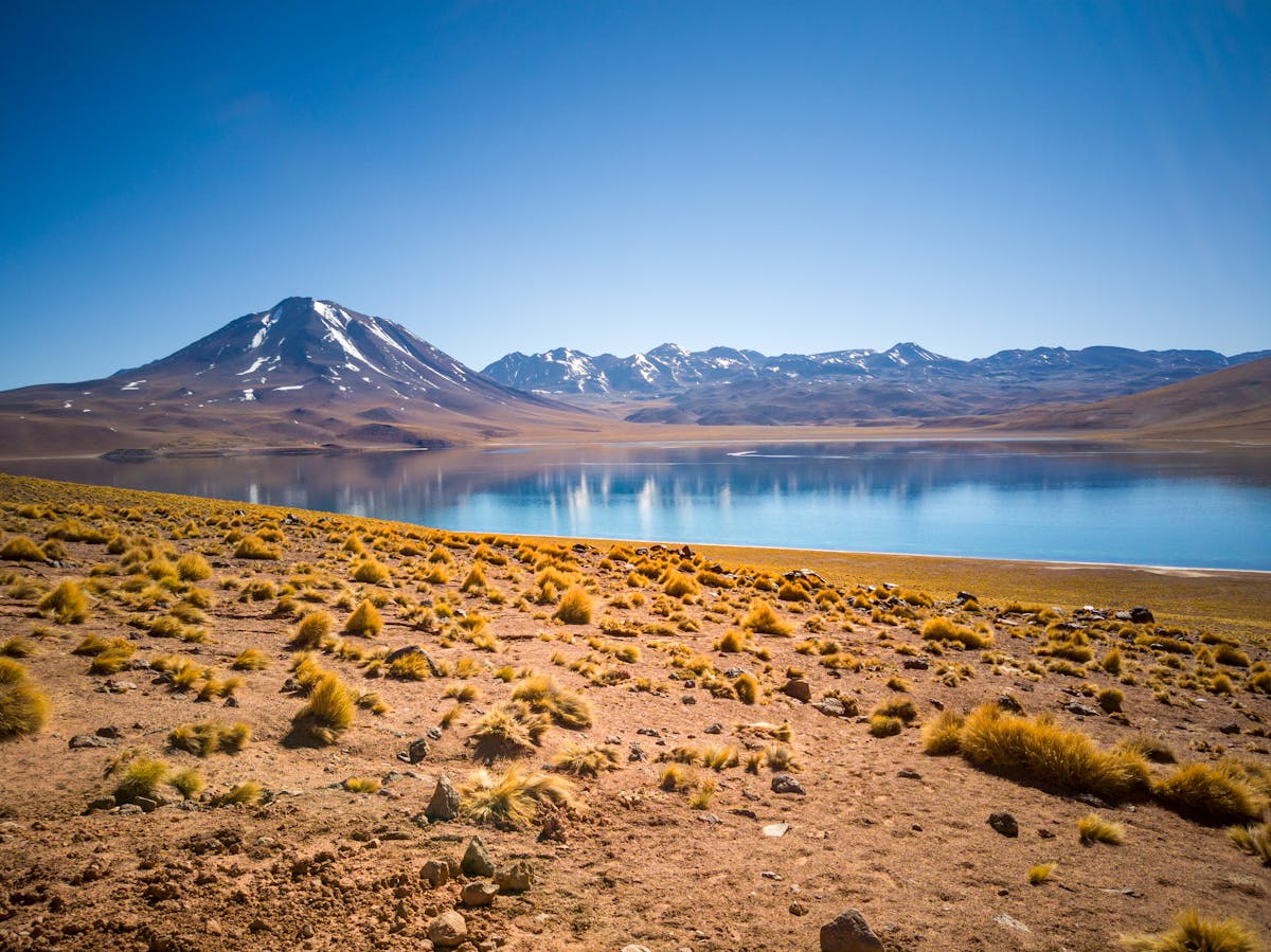 Atacama Desert mountain and lagoon with snow-capped peaks under a clear sky