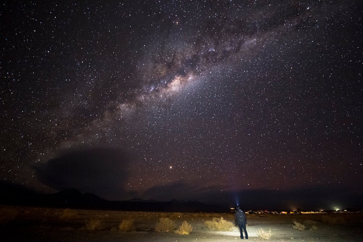 Person standing alone under the Milky Way in the Atacama Desert at night