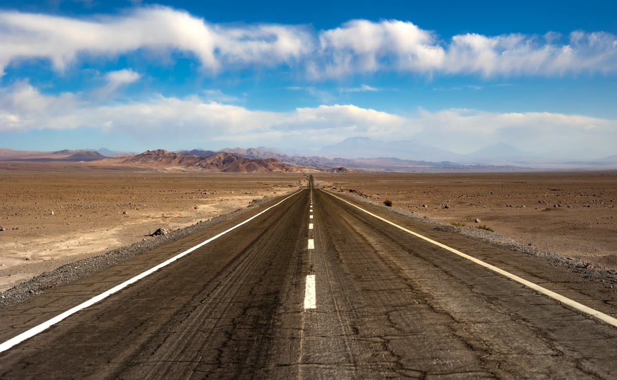 A scenic highway stretching through the Atacama Desert in Chile with mountains in the background