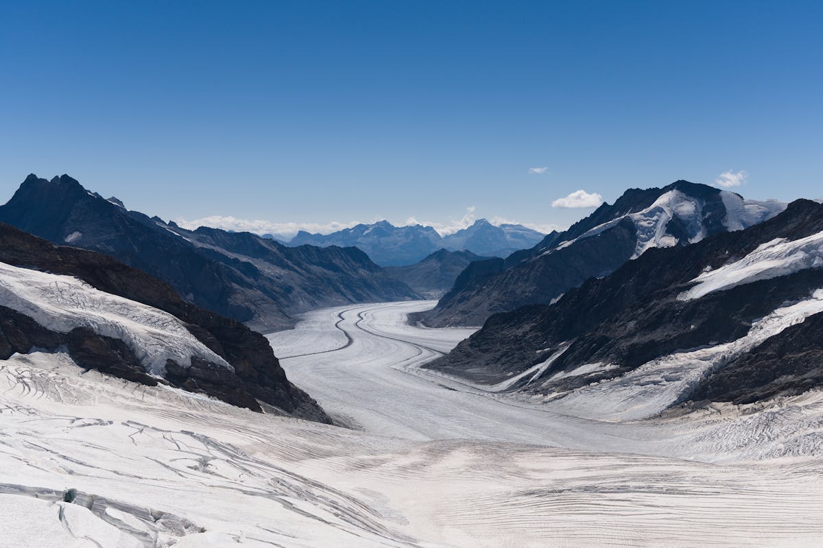 Glacier and snow-covered mountain peak with hiking trail visible in foreground