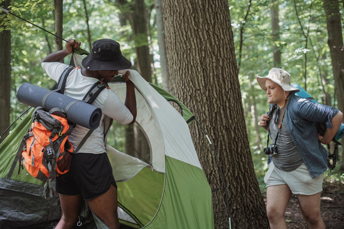 Camping equipment laid out including tent, sleeping bag, and cooking gear
