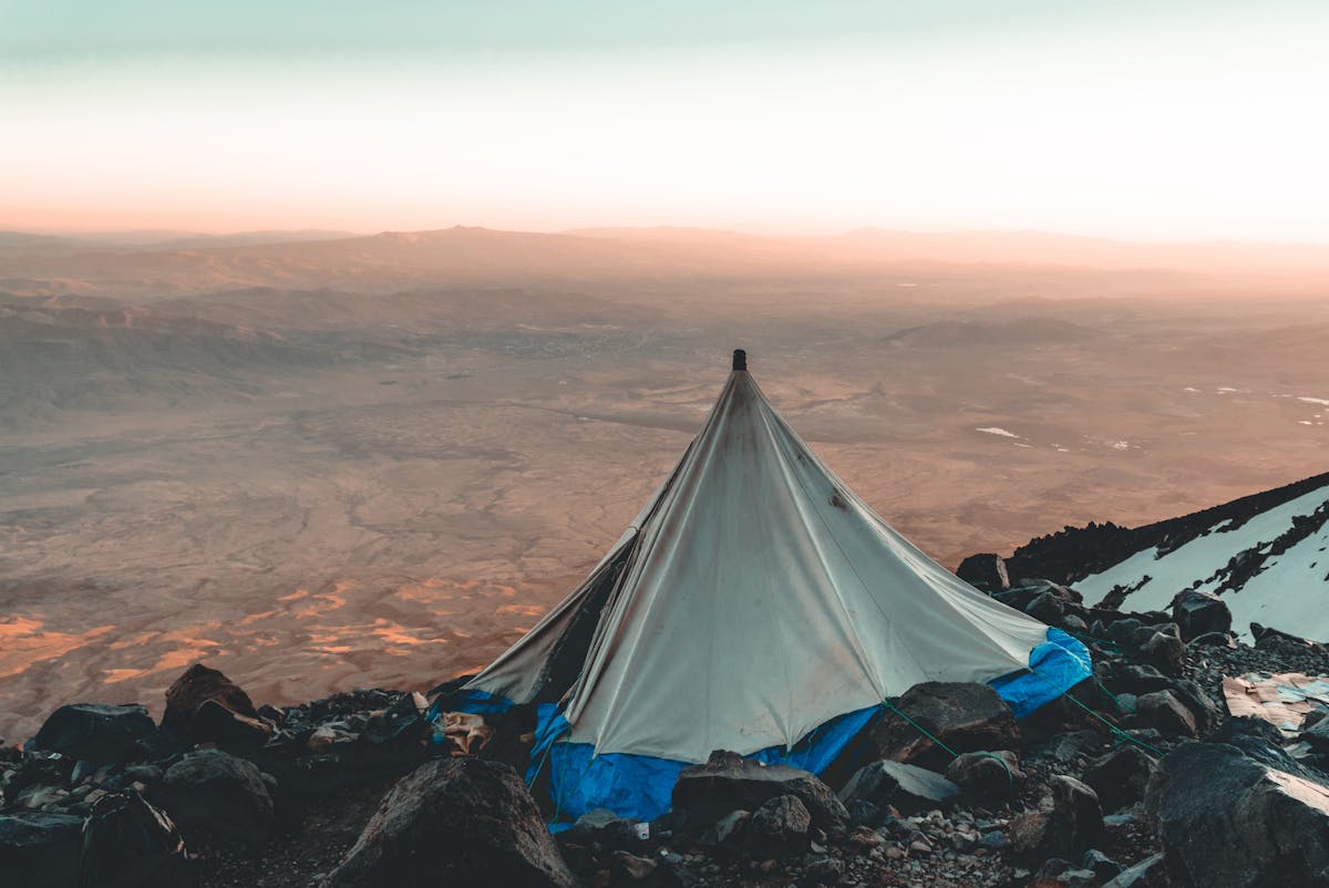 Tent at sunrise in a mountain meadow with golden light