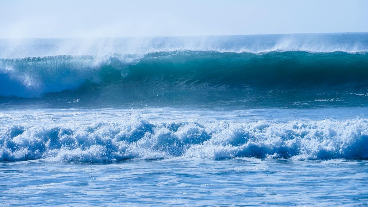 Surfers riding waves along the coast of Pichilemu, Chile's surf capital