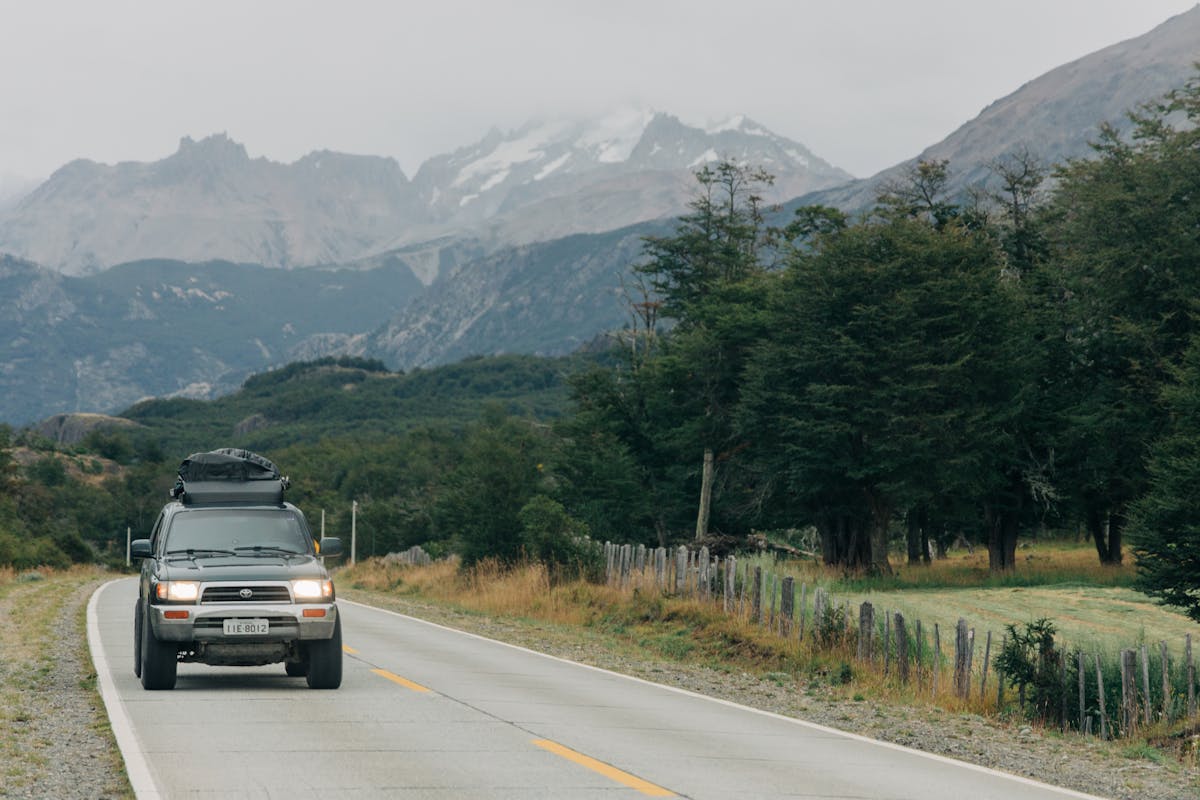 Winding mountain road through dramatic Chilean landscape with snow-capped peaks in the distance