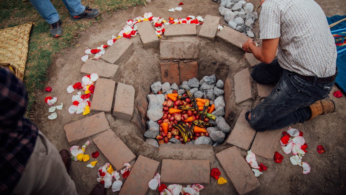 Traditional underground oven with vegetables and food being prepared for cooking