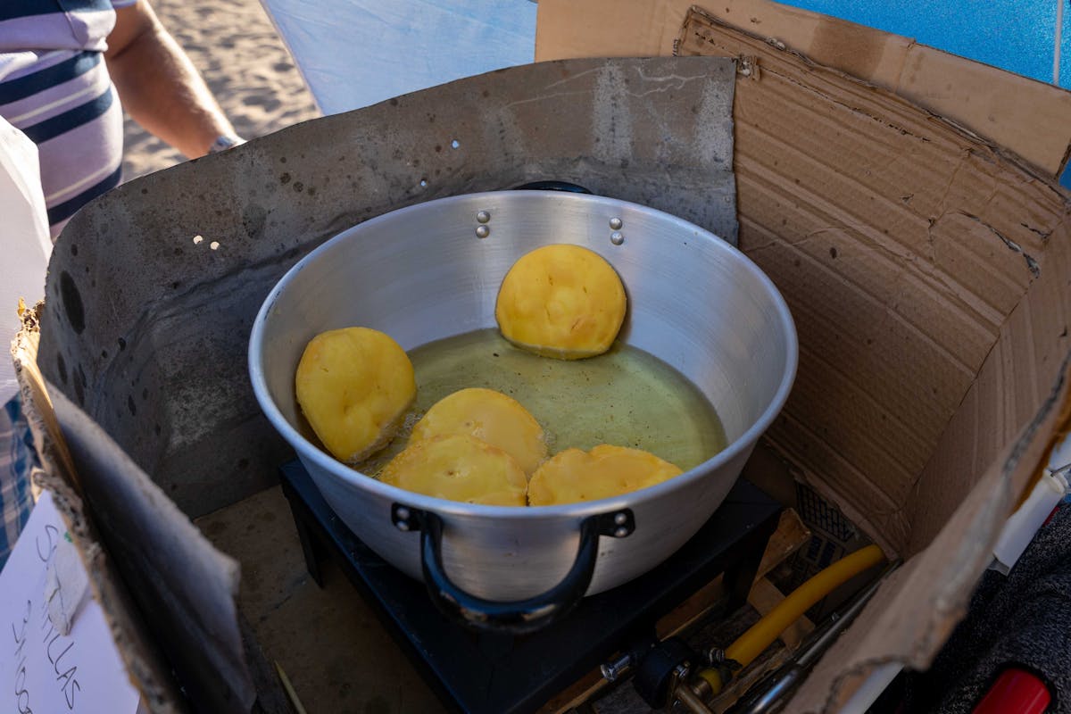 Sopapillas frying in oil at a Chilean street food market
