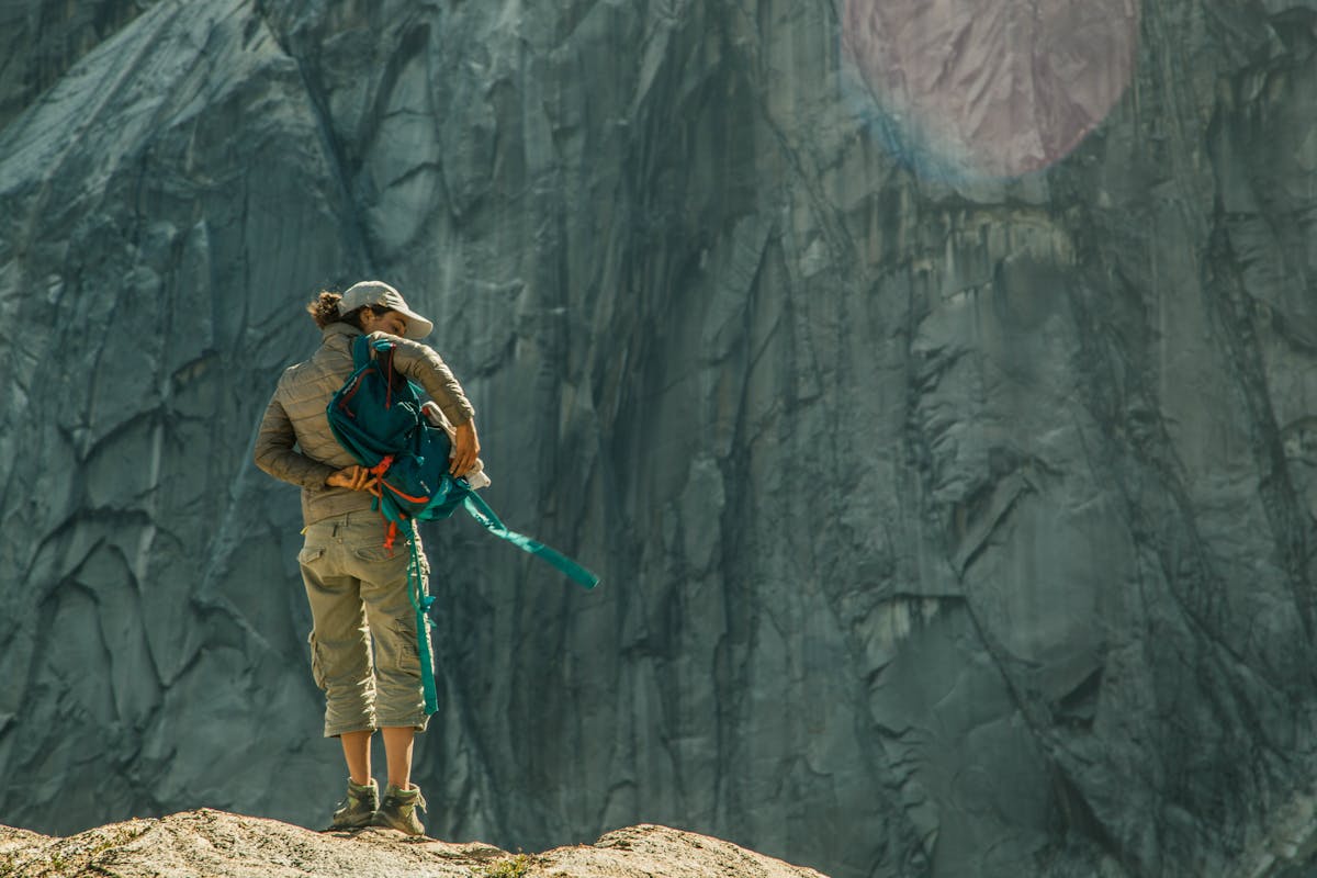 Solo hiker preparing climbing gear in the forested mountains of Cochamo, Chile