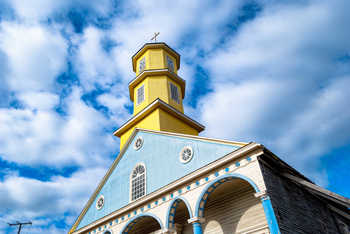 Colorful wooden church with striking architecture under a bright sky in southern Chile
