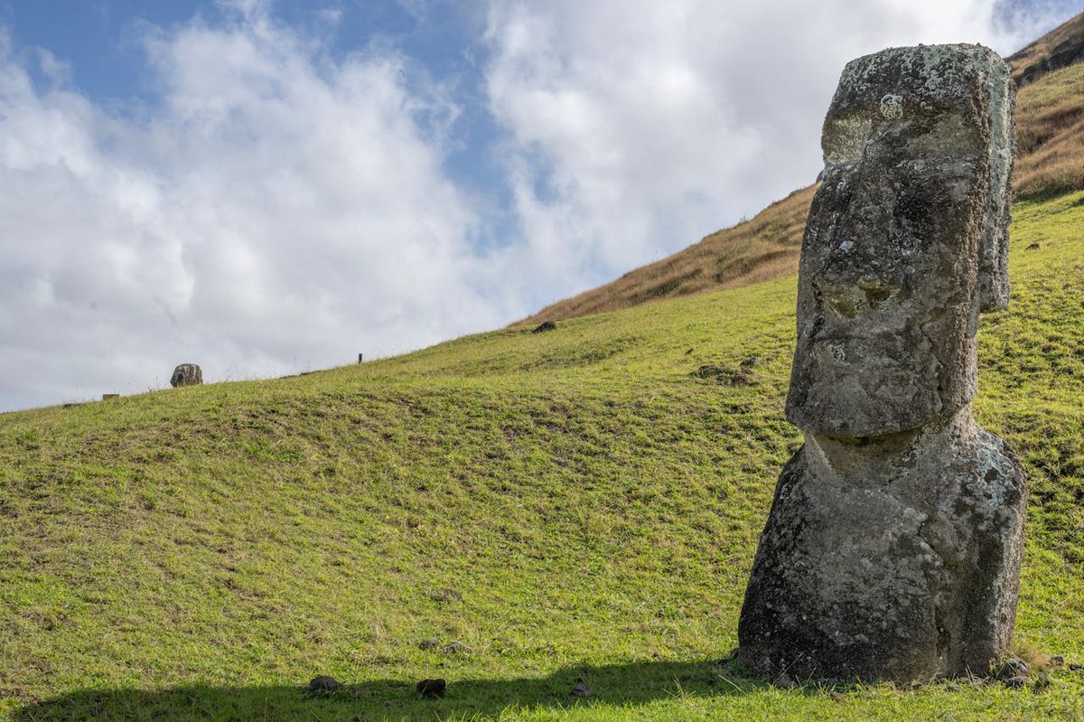 Close-up view of a single moai statue on Easter Island under bright cloudy sky