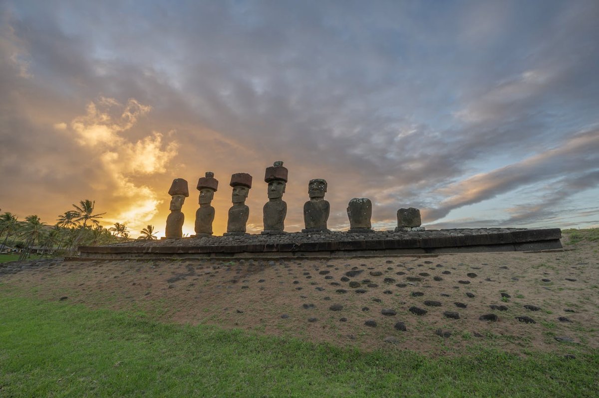 Silhouettes of moai statues at Ahu Tongariki against a colorful sunrise sky on Easter Island