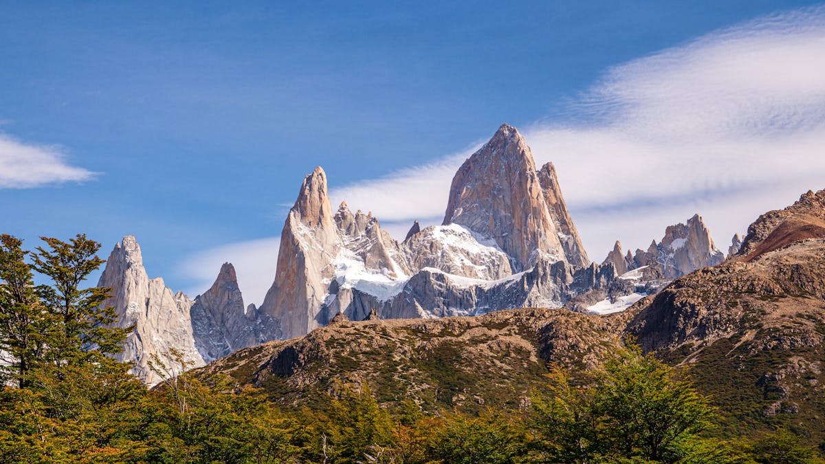 Panoramic view of Fitz Roy massif with green foreground terrain in Patagonia