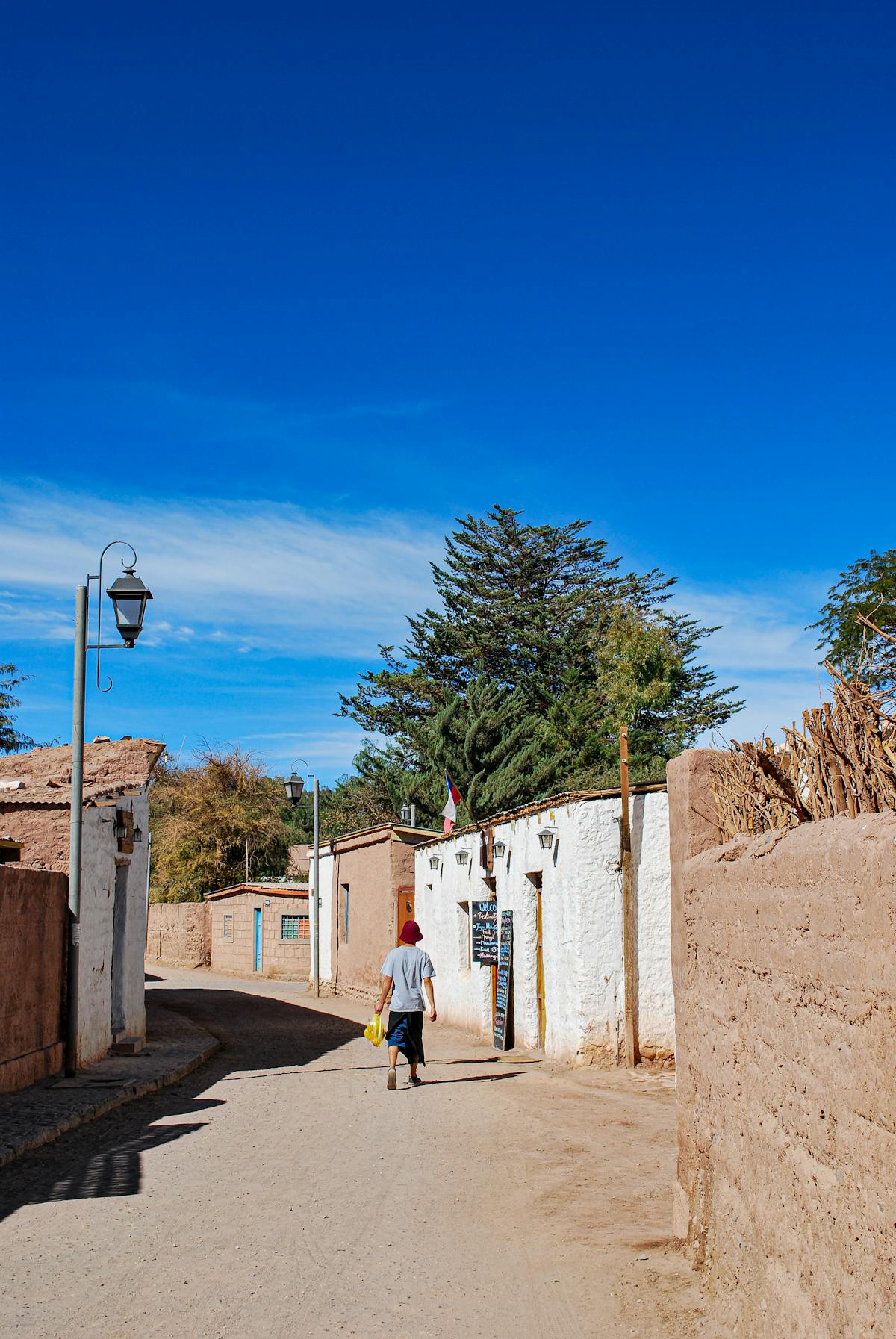 Traditional street in a small Chilean village with adobe-style buildings under a bright blue sky