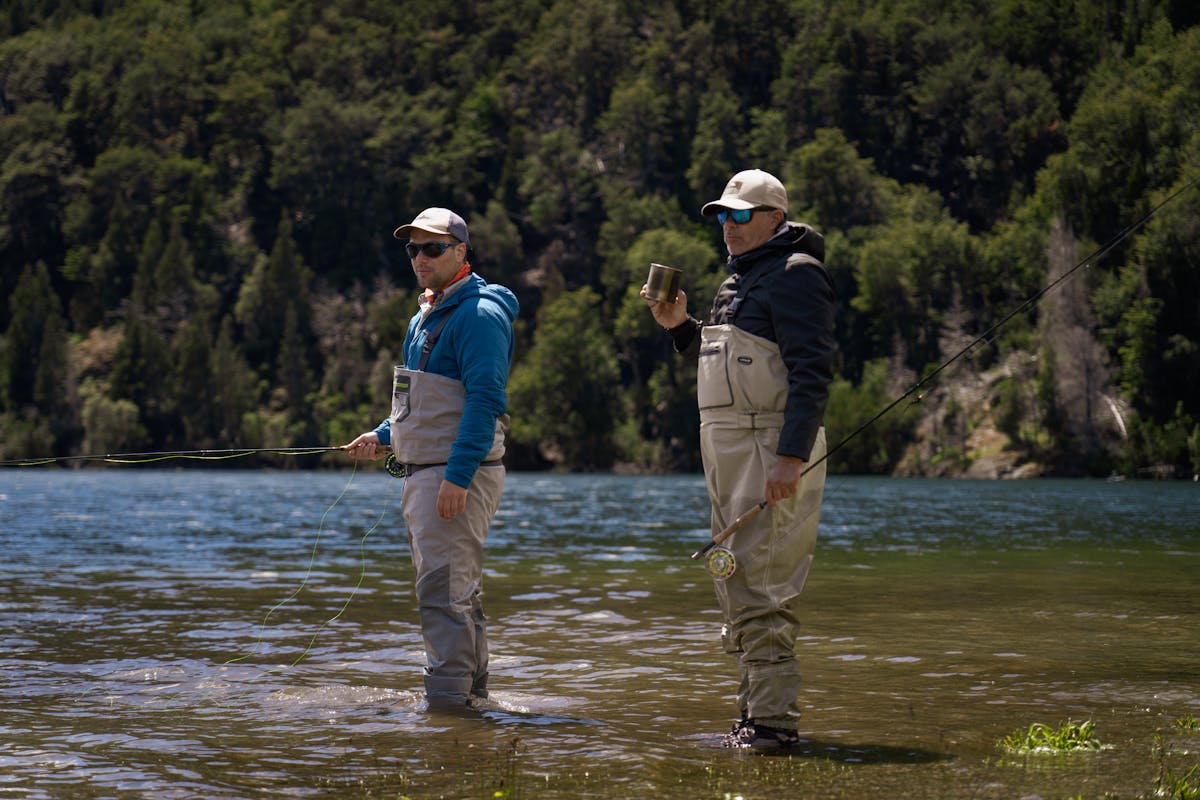 Two anglers fly fishing together in the clear waters of a Patagonian river
