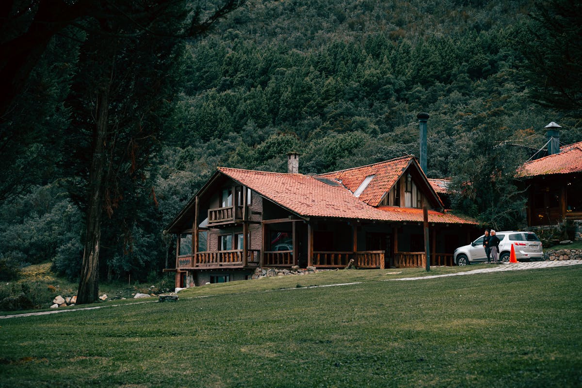 Wooden fishing lodge surrounded by forest and mountains in a remote mountain setting