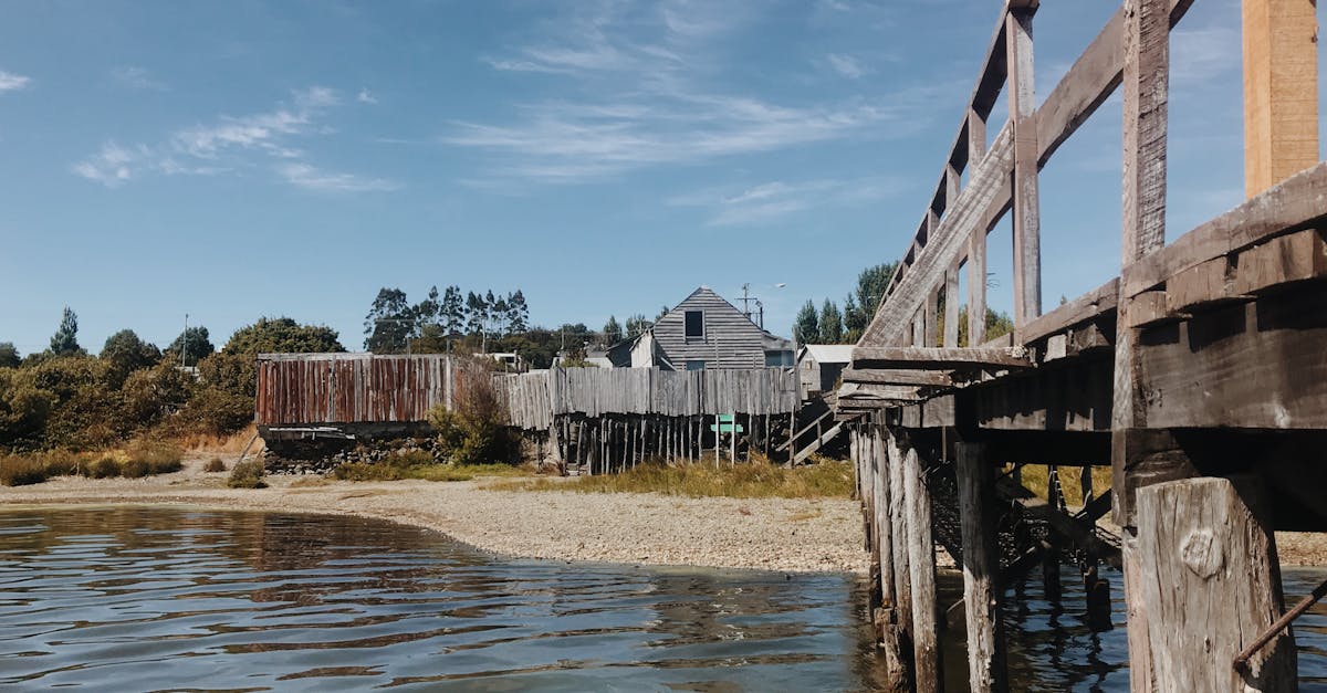 Rustic pier with traditional wooden houses along a lakefront in Los Lagos, Chile