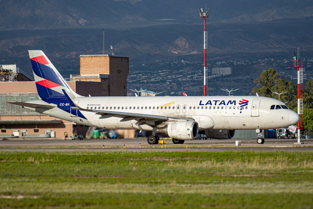 LATAM Airbus A320 on a runway with mountains visible in the background