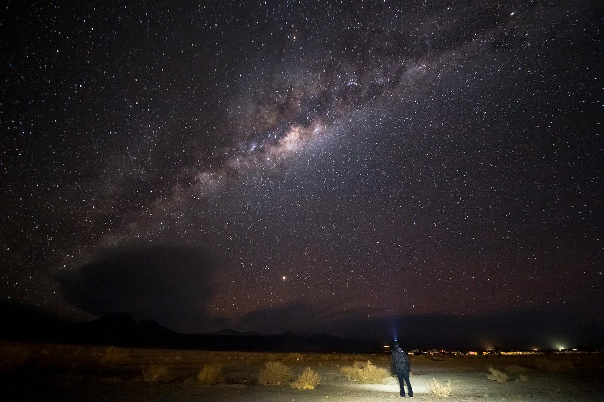 Person standing beneath the Milky Way in the Atacama Desert at night