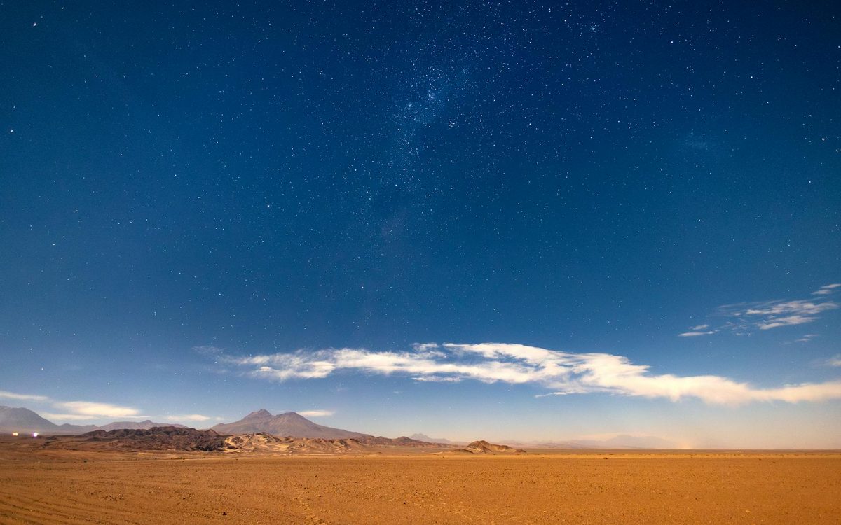 Starry night sky stretching over the vast Atacama Desert landscape in Chile