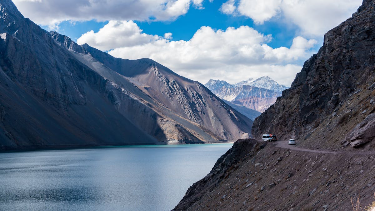 Dramatic view of Andes mountains surrounding a turquoise lake in the Santiago Metropolitan Region