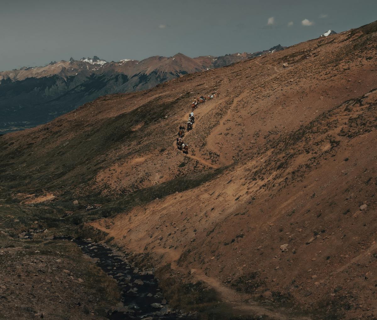 Aerial view of a horseback riding trail winding through vivid mountainous landscape