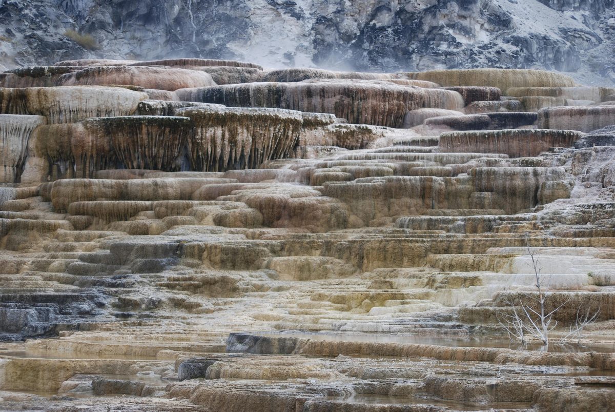Dramatic travertine mineral terraces with flowing thermal water in a mountainous setting