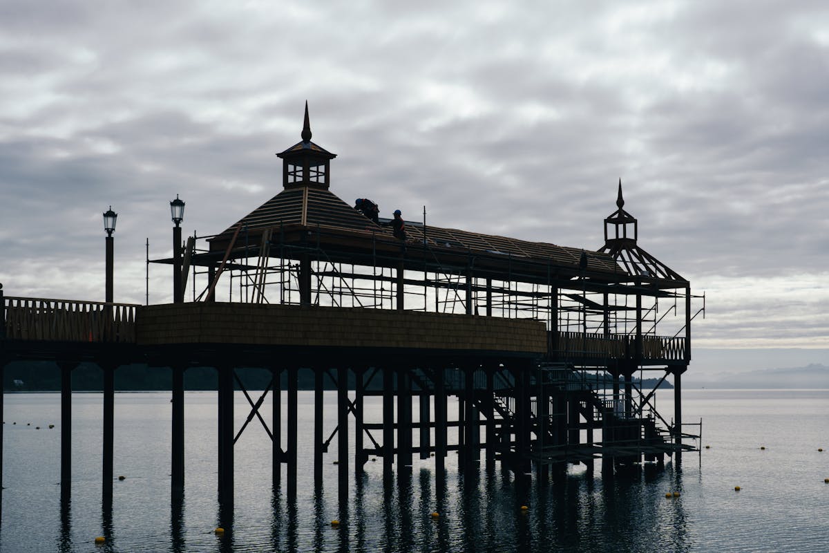Scenic pier stretching into a lake in Frutillar, Chile, with mountains in the distance
