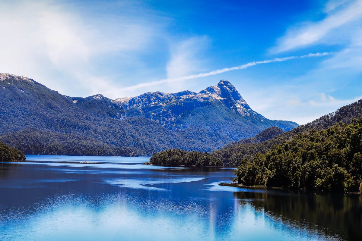 Clear blue lake surrounded by lush forests and mountains in southern Chile
