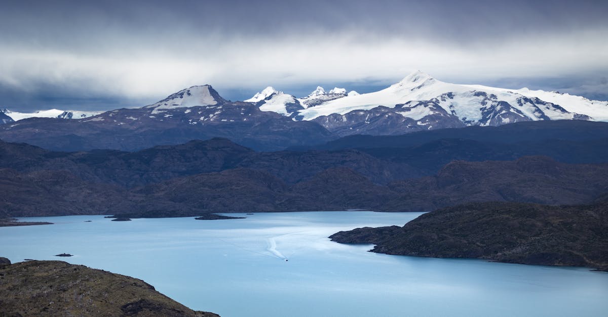 Chilean Patagonia lake framed by snow-capped mountains under moody clouds