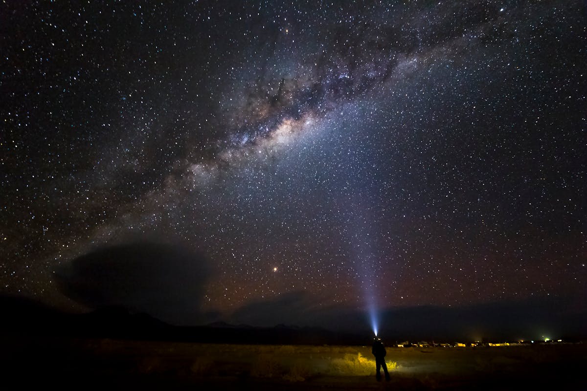 Person gazing at the Milky Way in San Pedro de Atacama Chile with desert landscape