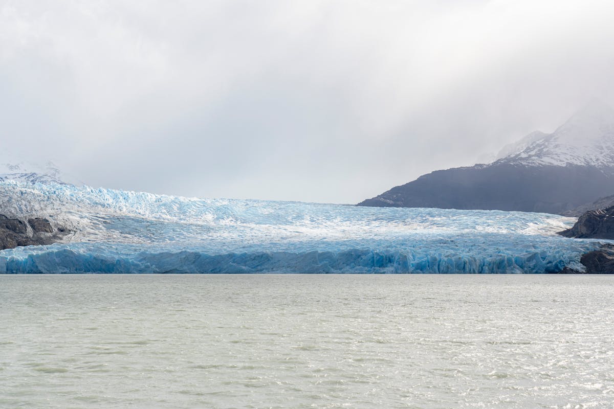 Majestic glacier surrounded by mountains and turquoise lake in Torres del Paine Chile