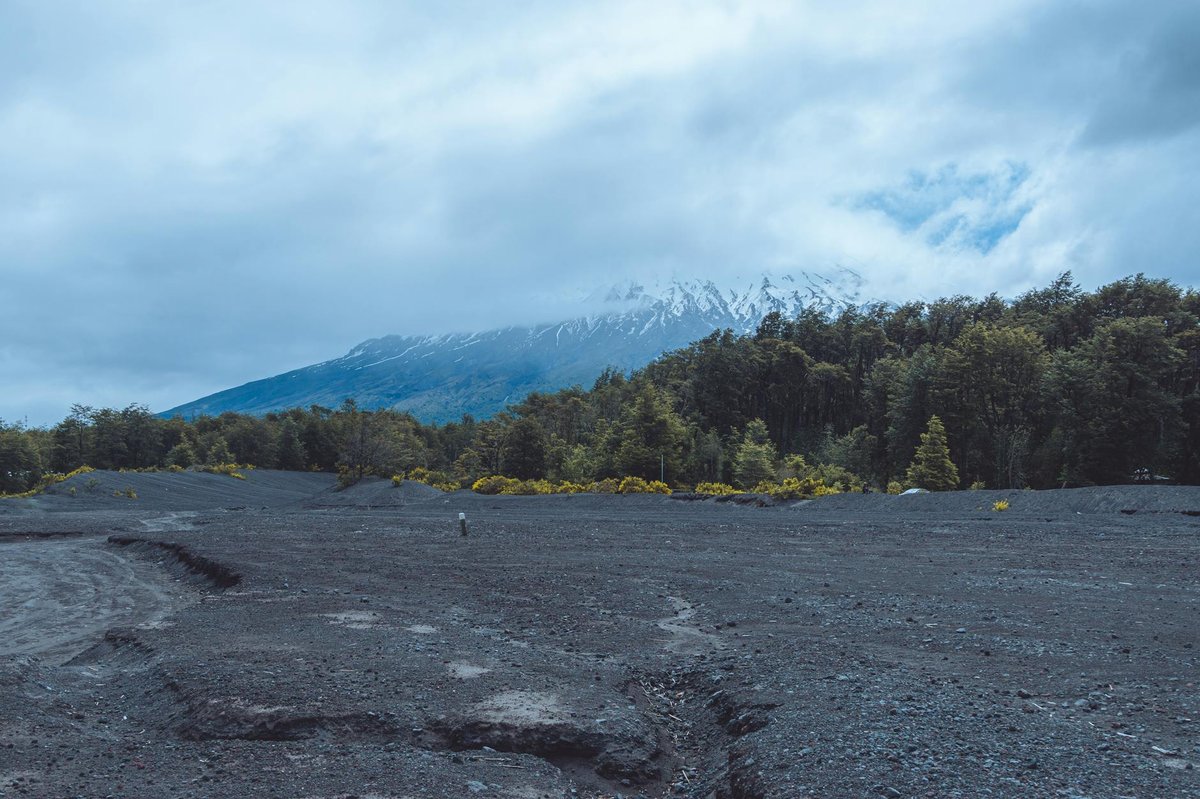 Dramatic volcanic terrain in Chile's Lake District with clouds