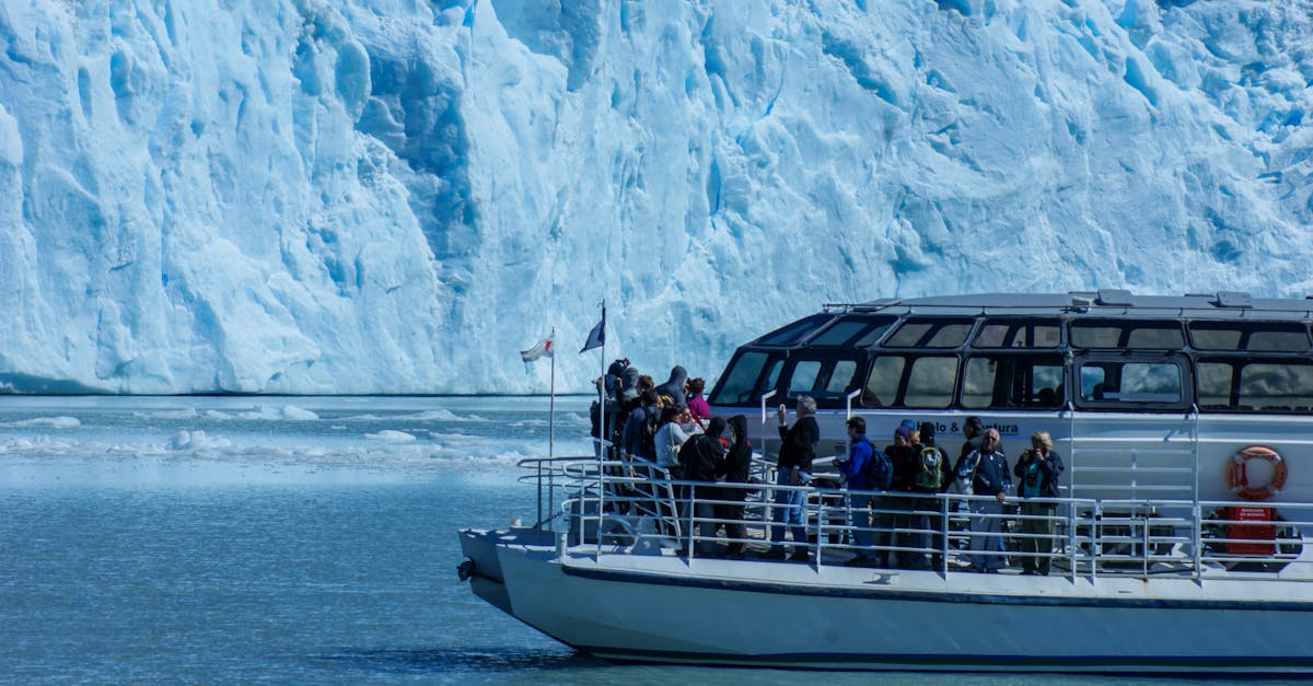 Tour boat approaching a blue glacier in Patagonia with ice floating in the water
