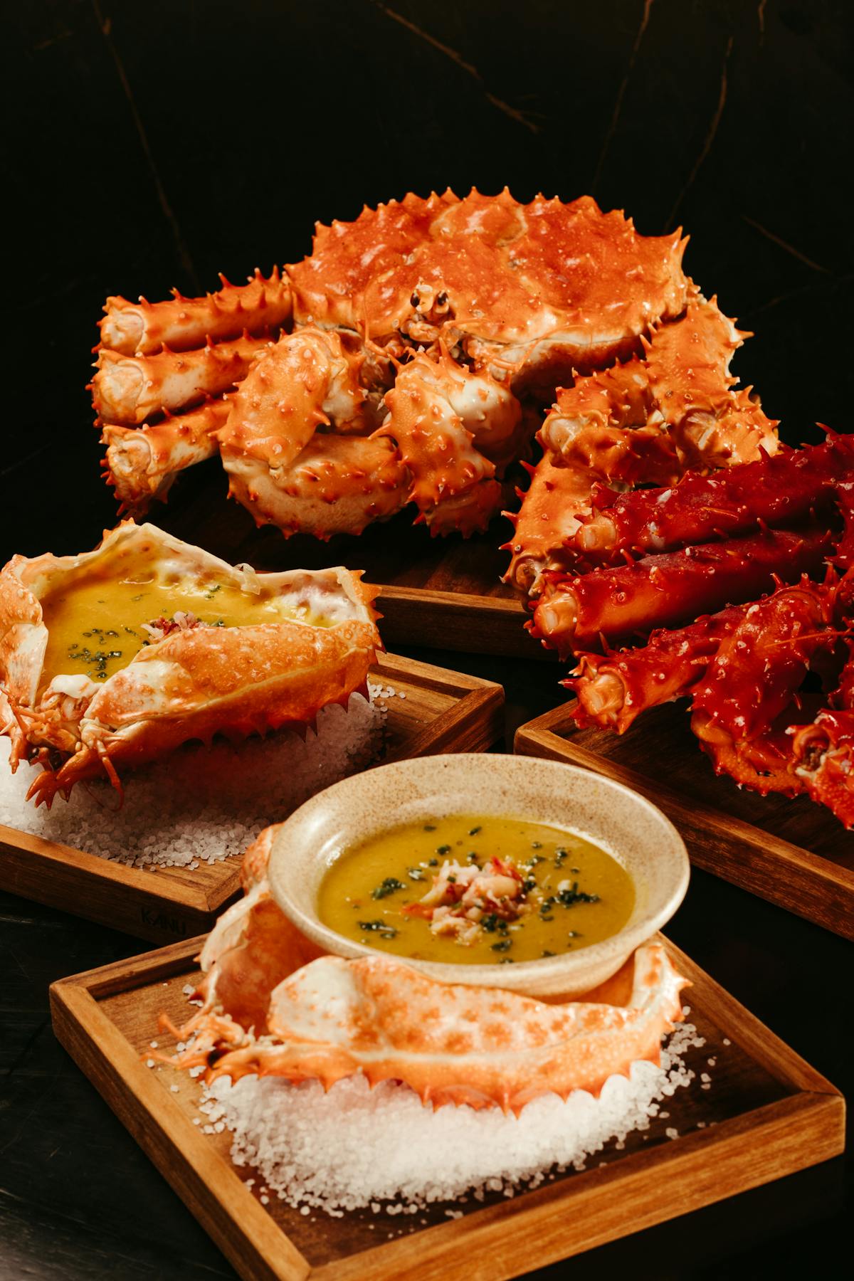 Gourmet king crab legs served with sauce on wooden boards