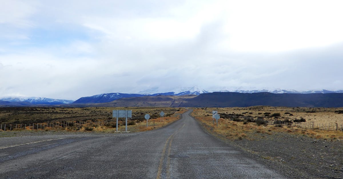 Empty gravel road stretching toward snow-capped mountains in Patagonia
