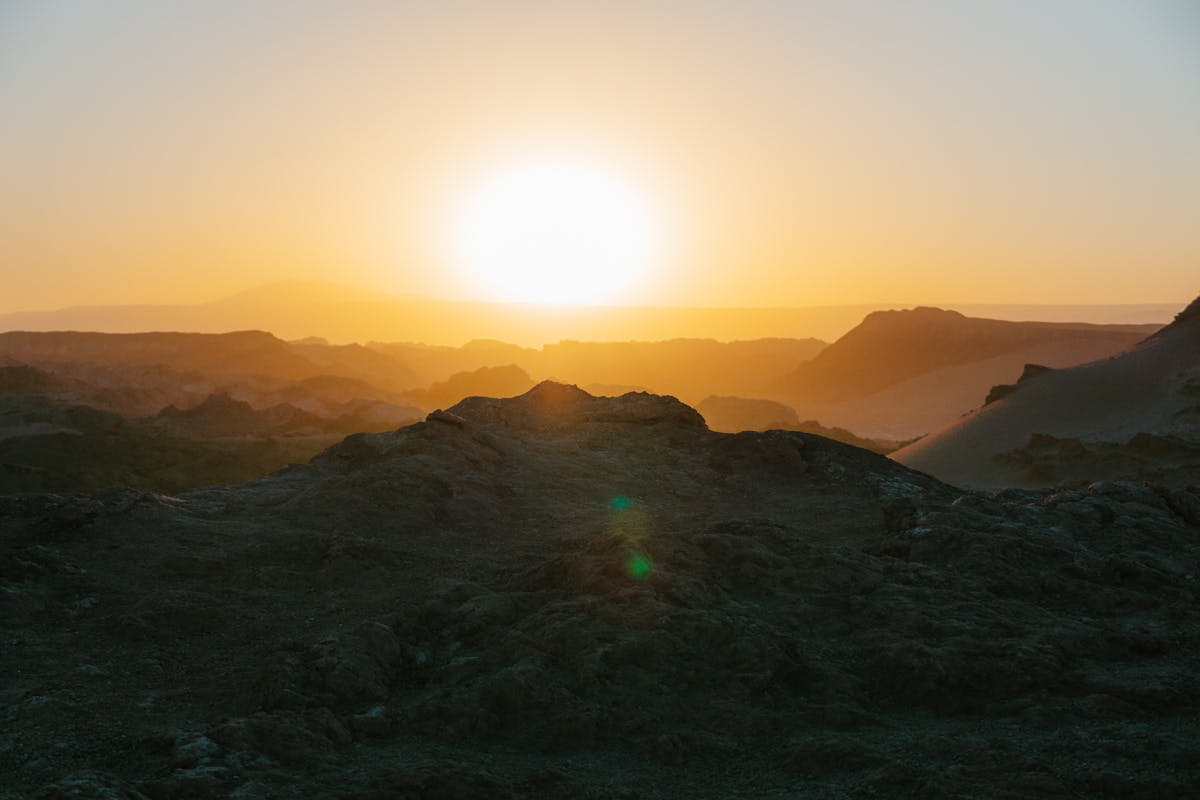 Sunset casting orange and red light across the rocky landscape of Valle de la Luna near San Pedro de Atacama