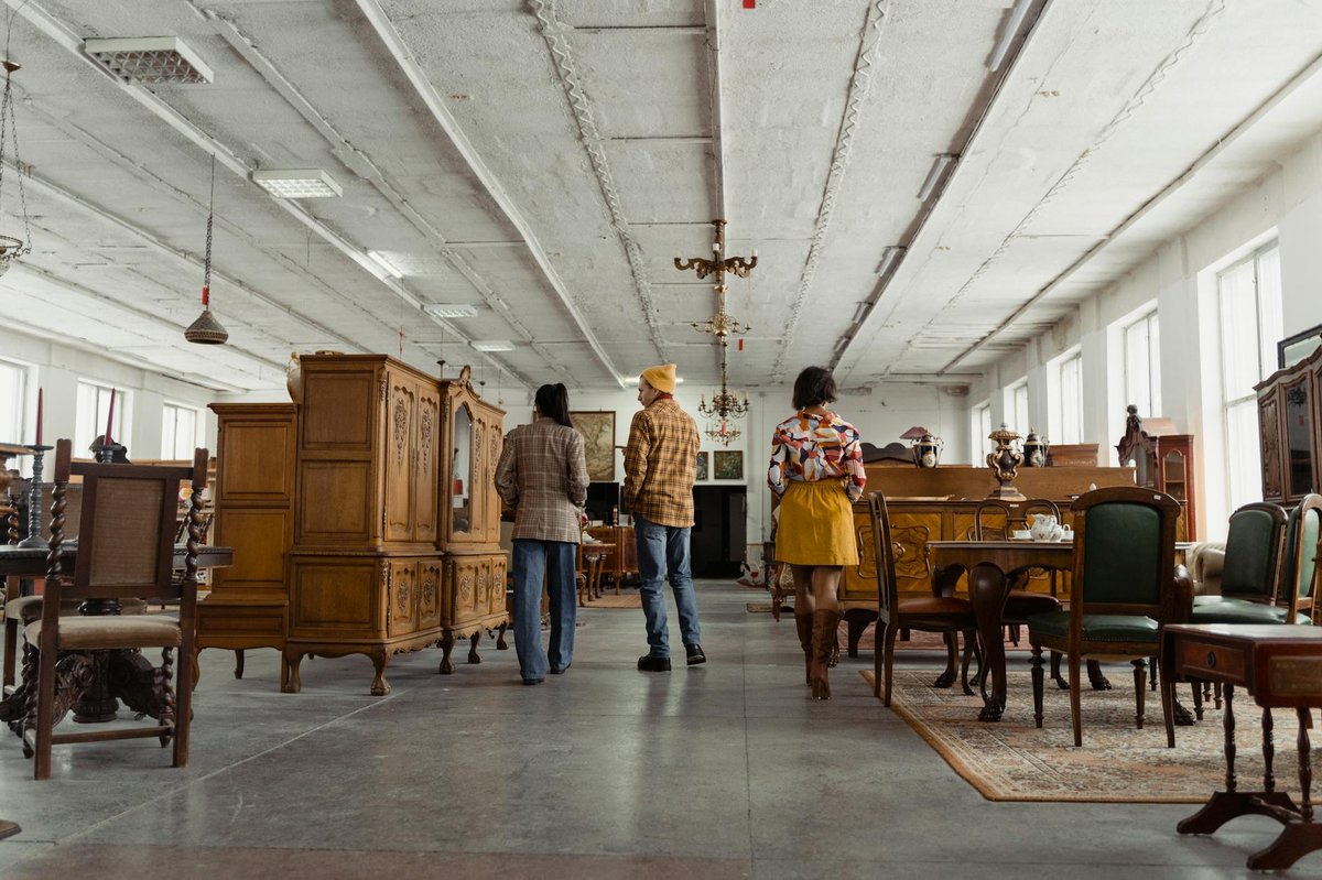 People browsing vintage furniture and antiques in a design store