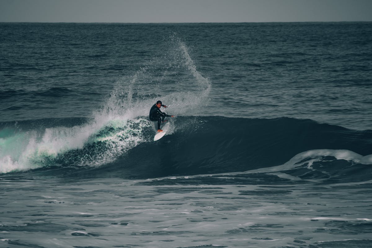 Surfer skillfully riding a powerful ocean wave during the day