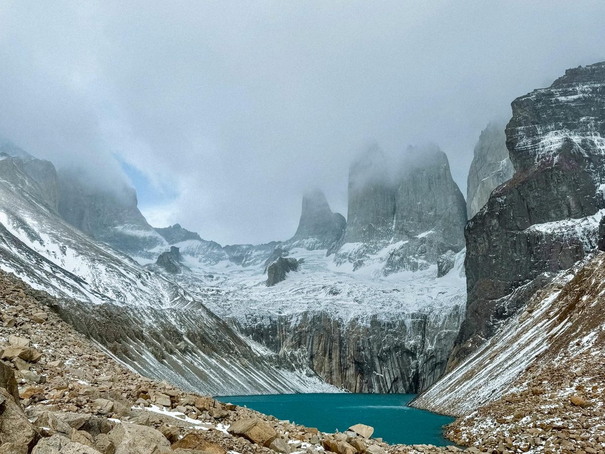 Snow-covered Torres del Paine peaks with glacial lake in foreground