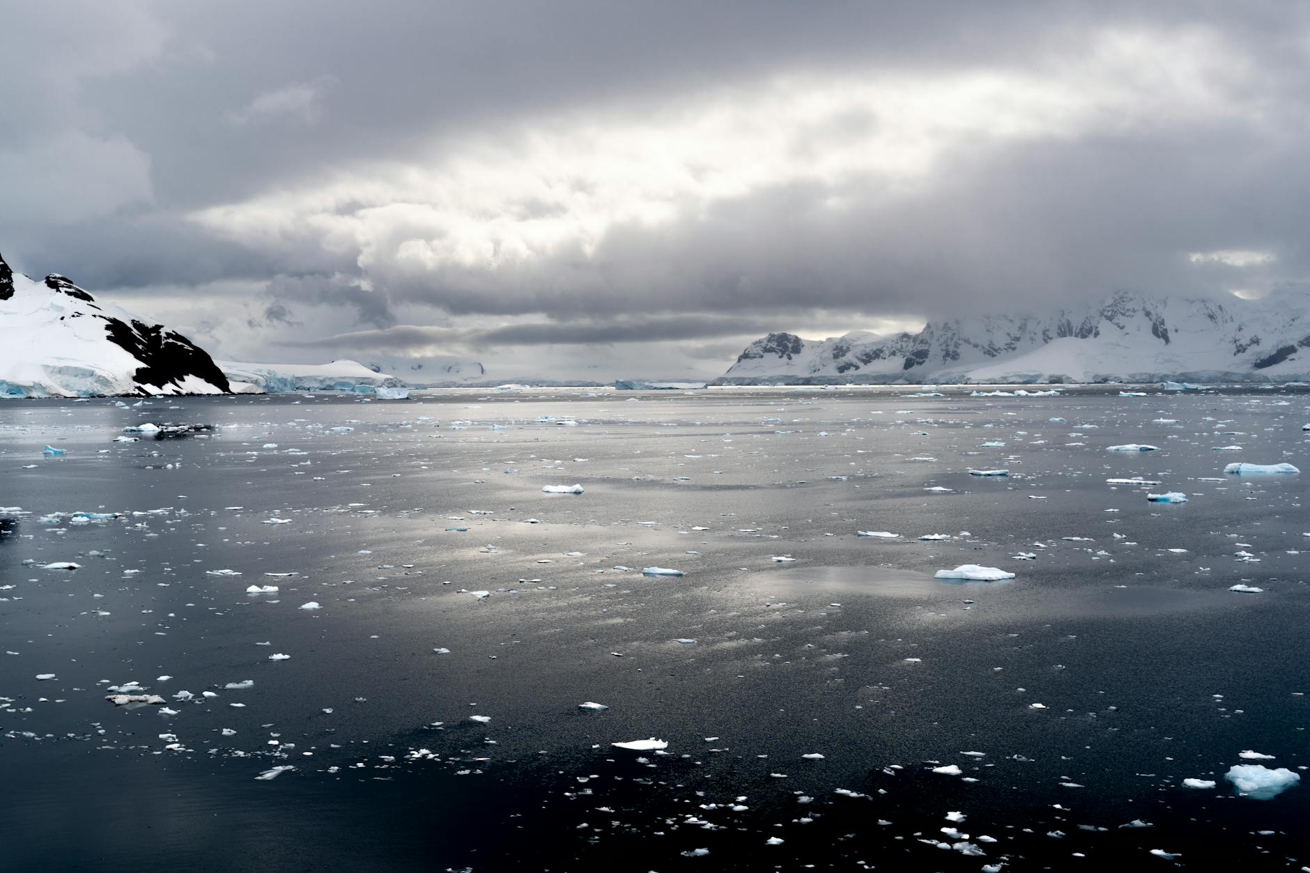 Dramatic view of icy Antarctic seas under dark dramatic clouds with distant ice formations