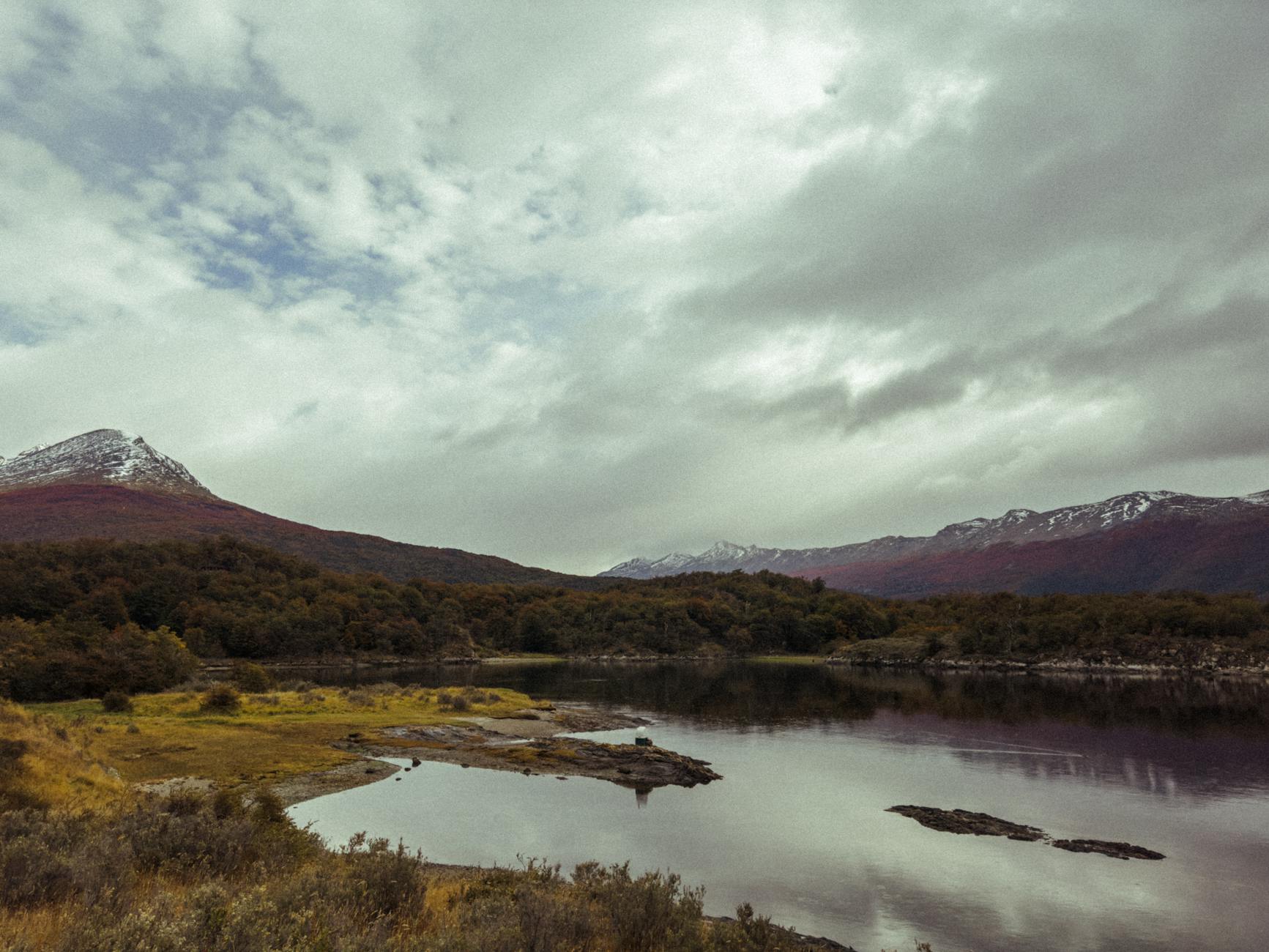 Lake and mountain landscape near Ushuaia with overcast sky and lush vegetation
