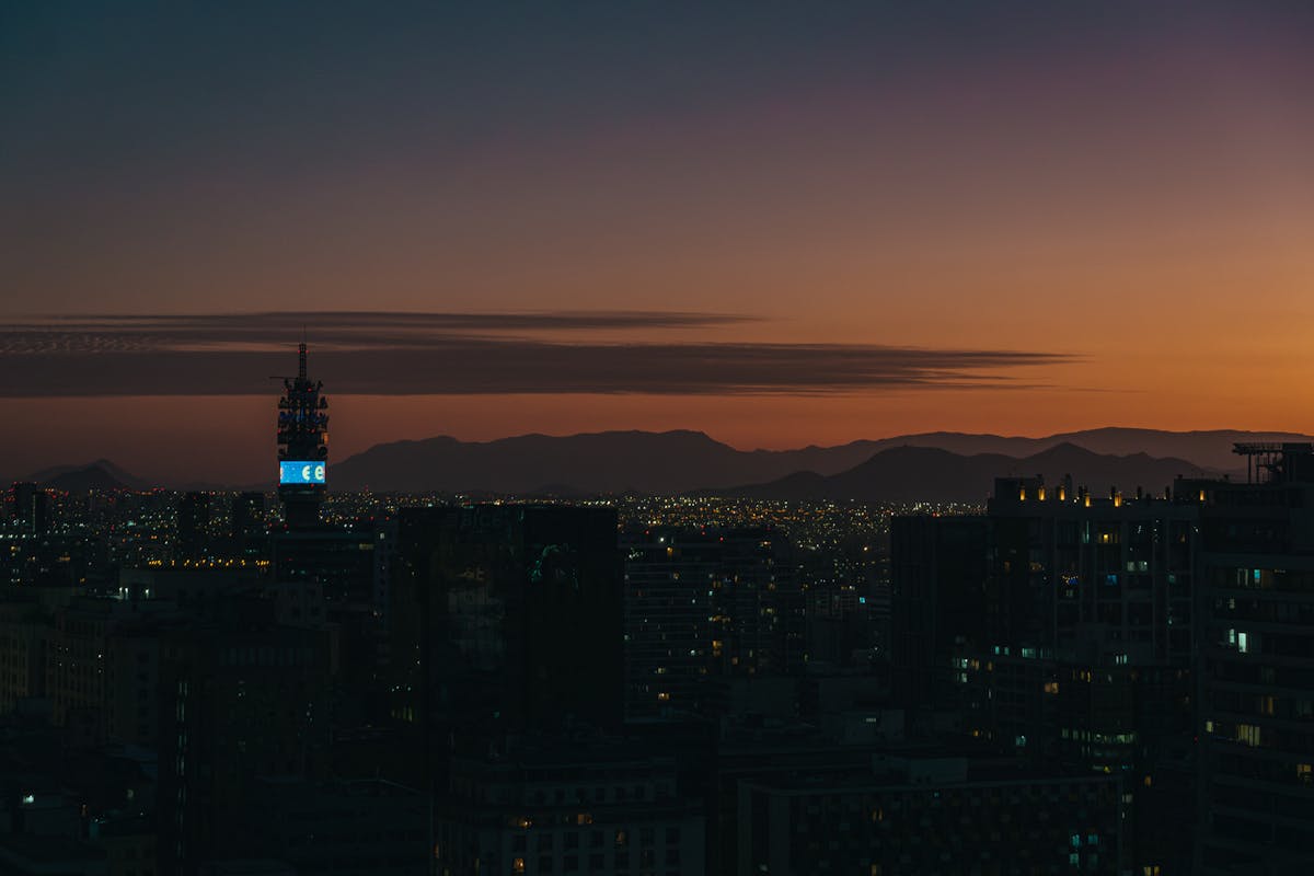 Twilight view of Santiago skyline with silhouetted buildings and mountains on the horizon