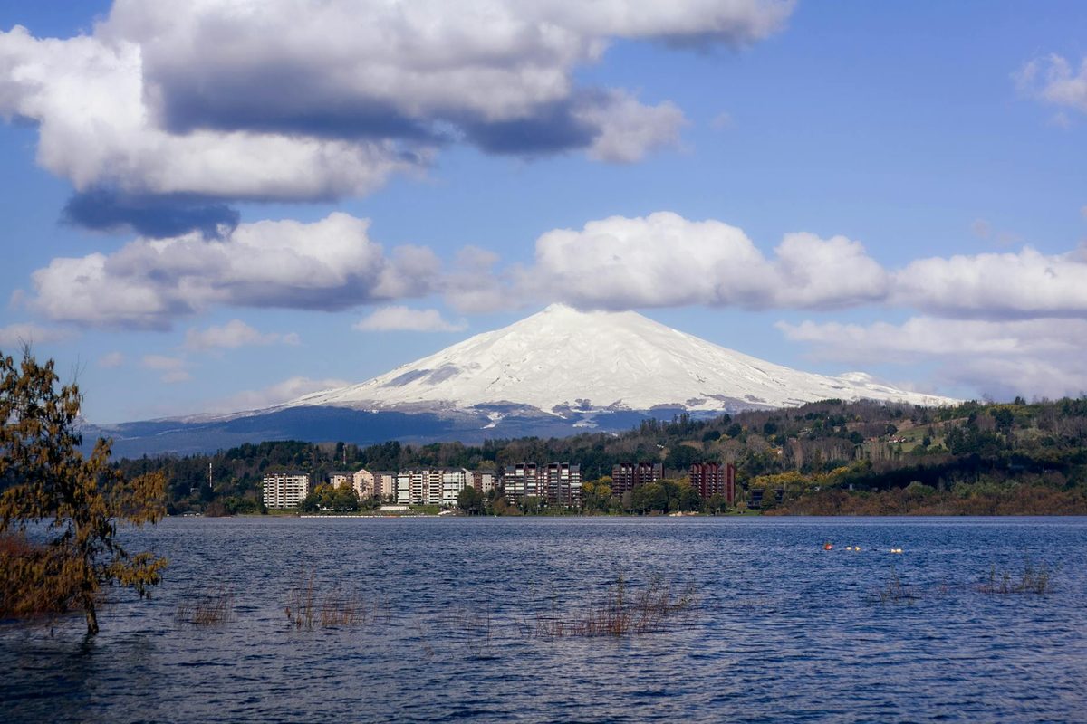 Snowcapped Villarrica Volcano rising above a calm lake in southern Chile