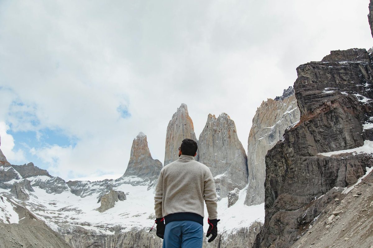 Hiker looking at snow-covered mountain peaks in Torres del Paine National Park