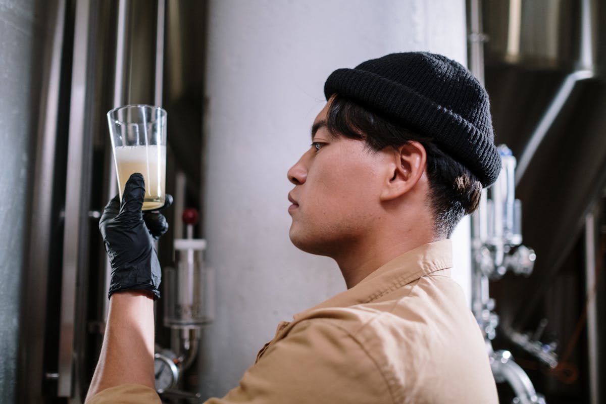 Brewmaster inspecting a glass of craft beer in a brewery setting
