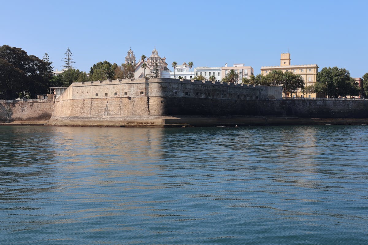 Ancient fortress walls along a scenic coastline under blue sky