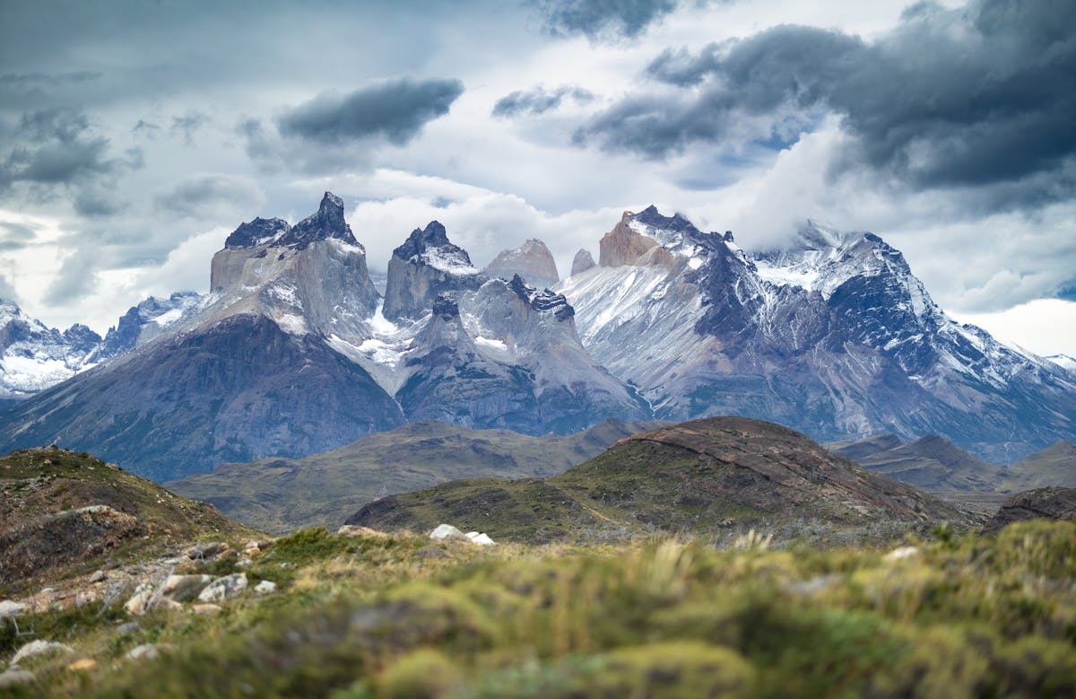 Dramatic mountain landscape of Torres del Paine National Park with cloudy sky and rugged peaks